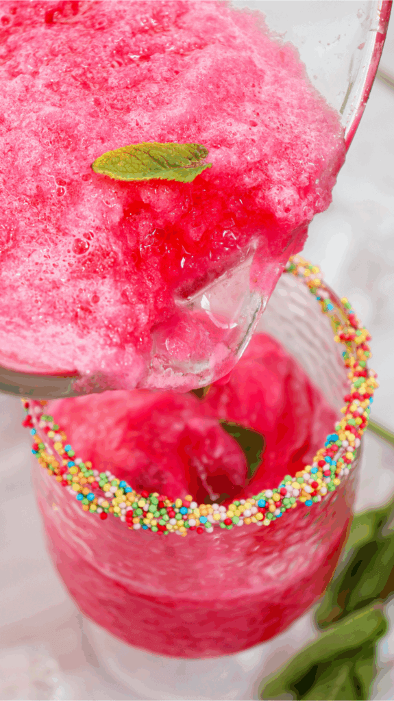 Close up of pouring the watermelon slushie into a glass from the blender.