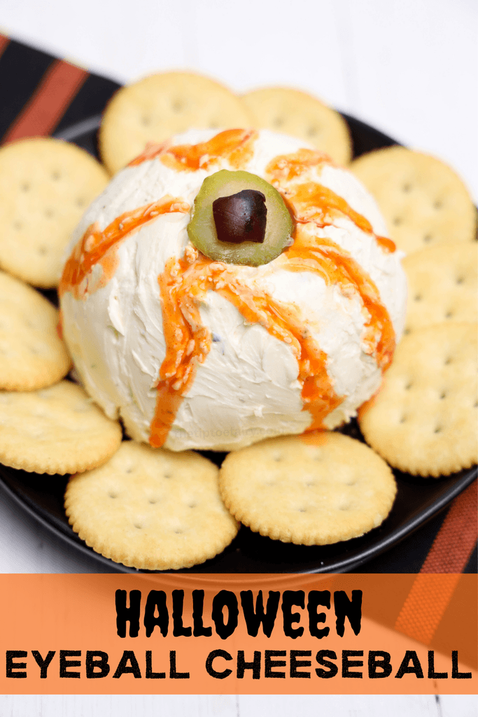 A close up of an eyeball made into a cheeseball with crackers around it for a halloween party.
